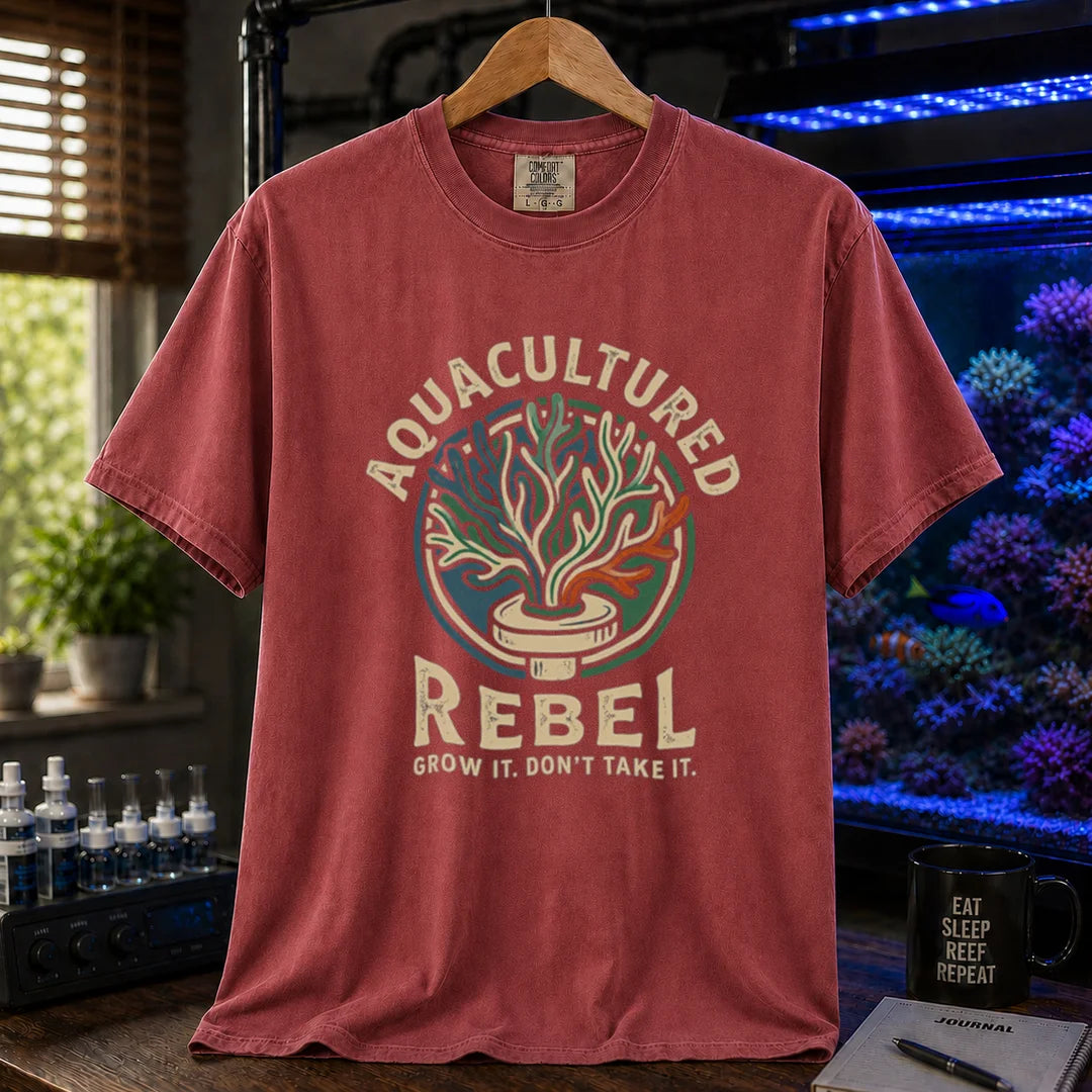 Saltwater aquarium graphic t-shirt design featuring a vintage badge reading Aquacultured Rebel Grow It. Don't Take It. with a coral frag plug illustration on a maroon, red tee
