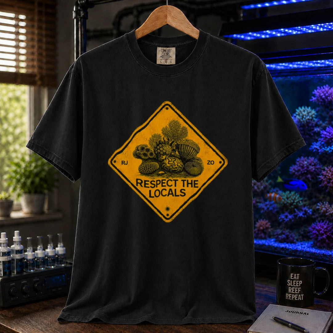Saltwater aquarium graphic t-shirt design featuring a distressed yellow diamond warning sign reading Respect The Locals with detailed coral and sea life illustrations on a black tee