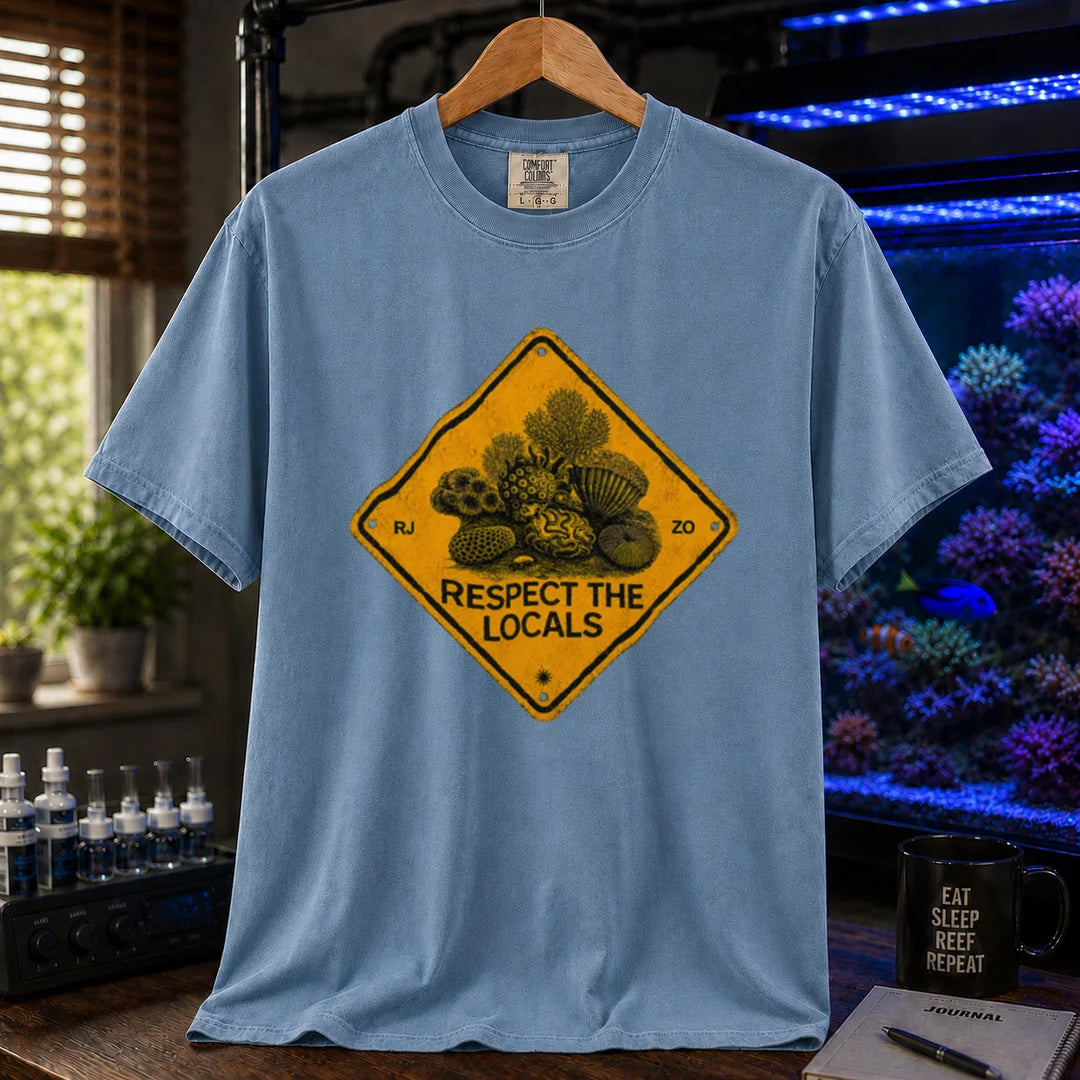Saltwater aquarium graphic t-shirt design featuring a distressed yellow diamond warning sign reading Respect The Locals with detailed coral and sea life illustrations on a blue tee