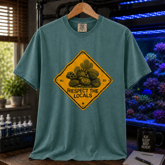 Saltwater aquarium graphic t-shirt design featuring a distressed yellow diamond warning sign reading Respect The Locals with detailed coral and sea life illustrations on a green tee