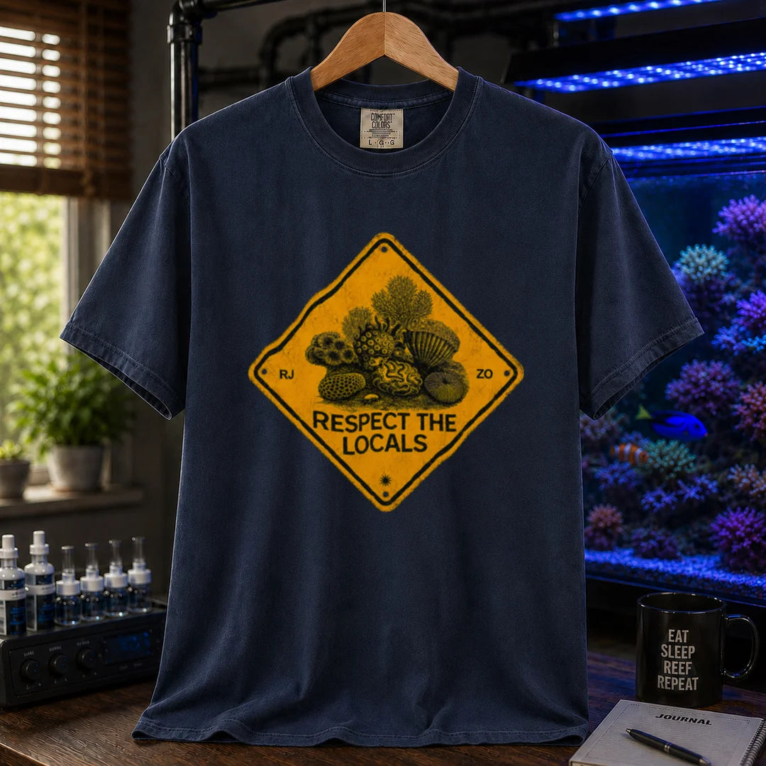 Saltwater aquarium graphic t-shirt design featuring a distressed yellow diamond warning sign reading Respect The Locals with detailed coral and sea life illustrations on a NAVY tee