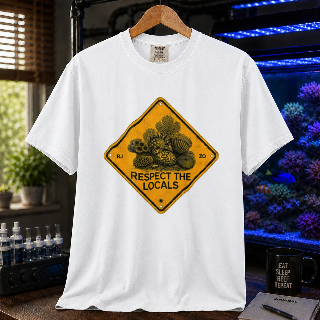 Saltwater aquarium graphic t-shirt design featuring a distressed yellow diamond warning sign reading Respect The Locals with detailed coral and sea life illustrations on a white tee