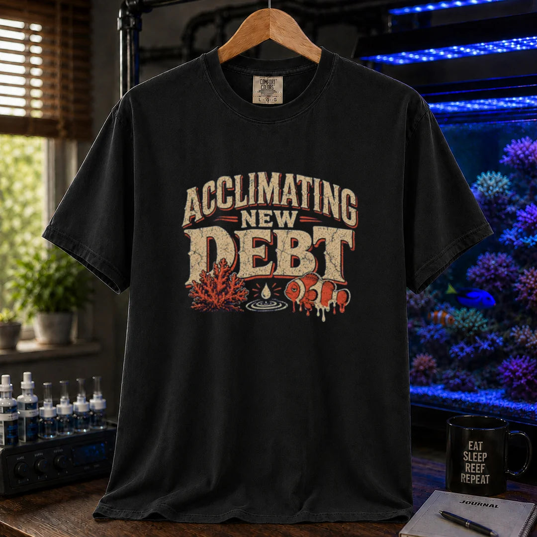 Saltwater aquarium graphic t-shirt design featuring distressed typography reading Acclimating New Debt with coral, water droplet, and clownfish illustrations on a black tee