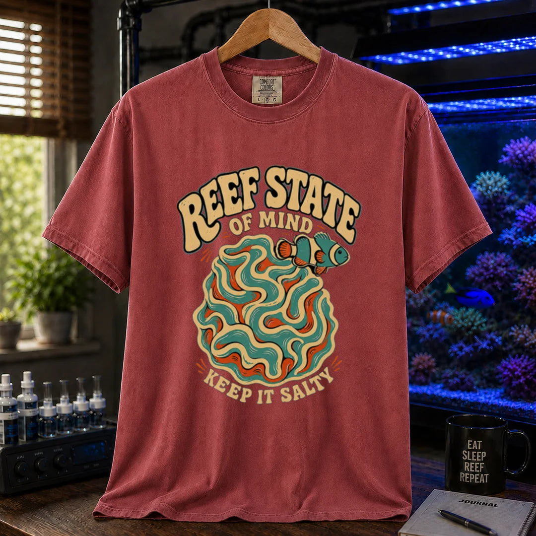 Saltwater aquarium graphic t-shirt featuring retro cream typography reading Reef State Of Mind Keep It Salty with a swirling abstract coral and clownfish design printed on a maroon, red tee displayed in a reef room setting