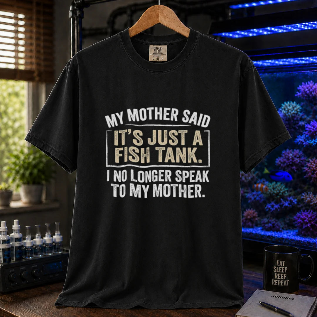 Saltwater aquarium graphic t-shirt featuring distressed white block typography reading My Mother Said It's Just A Fish Tank. I No Longer Speak To My Mother. printed on a black tee displayed in a reef room setting