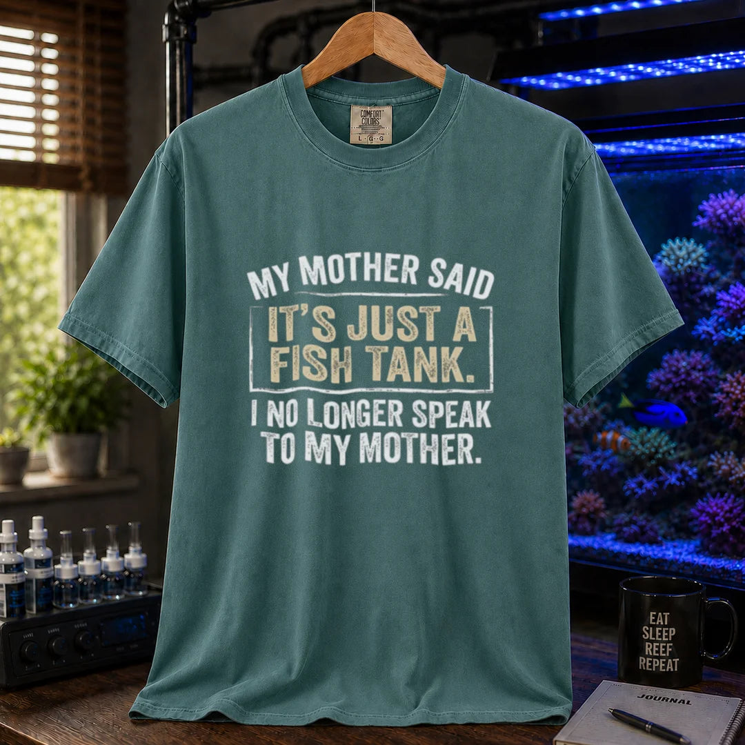 Saltwater aquarium graphic t-shirt featuring distressed white block typography reading My Mother Said It's Just A Fish Tank. I No Longer Speak To My Mother. printed on a green tee displayed in a reef room setting