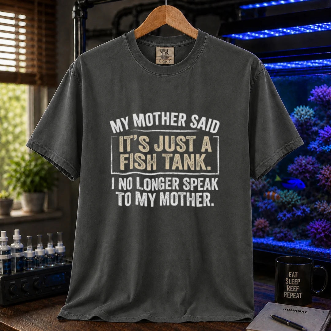 Saltwater aquarium graphic t-shirt featuring distressed white block typography reading My Mother Said It's Just A Fish Tank. I No Longer Speak To My Mother. printed on a dark grey tee displayed in a reef room setting