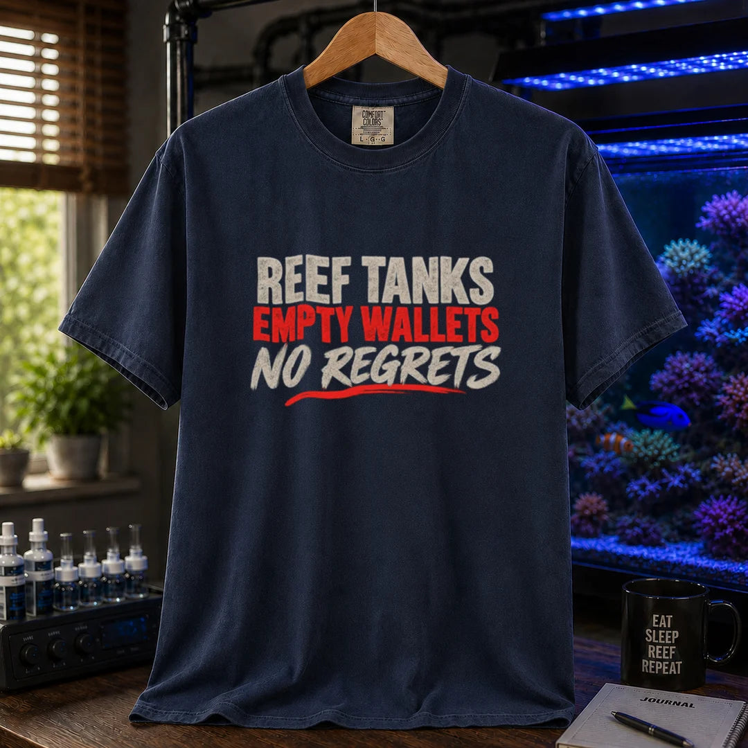 Saltwater aquarium graphic t-shirt featuring distressed cream and red typography reading Reef Tanks, Empty Wallets, No Regrets printed on a navy tee displayed in a reef room setting