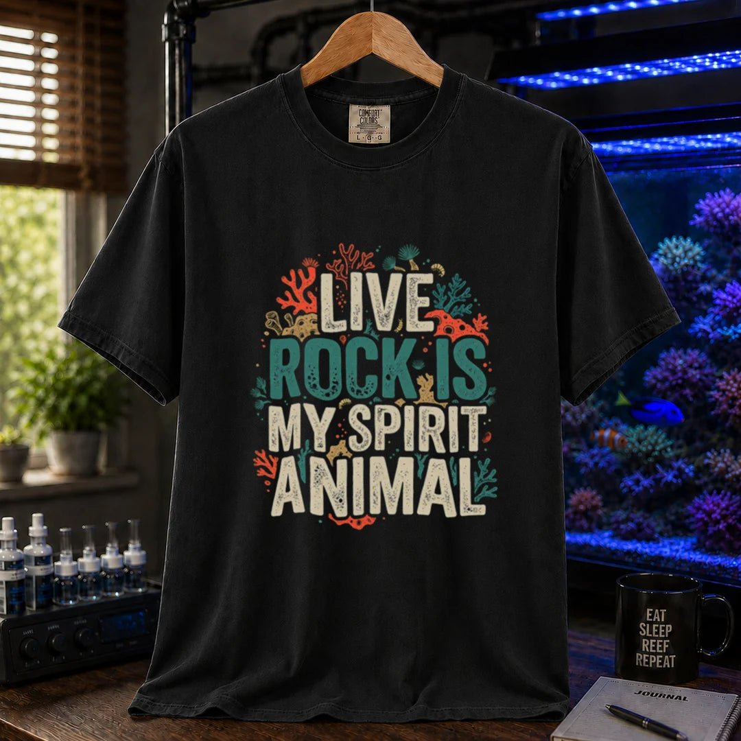 Saltwater aquarium graphic t-shirt featuring distressed cream and turquoise typography reading Live Rock Is My Spirit Animal framed by colorful coral illustrations printed on a black tee displayed in a reef room setting
