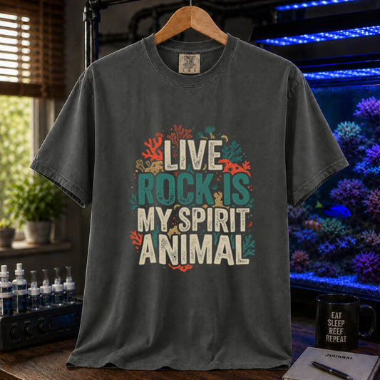 Saltwater aquarium graphic t-shirt featuring distressed cream and turquoise typography reading Live Rock Is My Spirit Animal framed by colorful coral illustrations printed on a dark grey tee displayed in a reef room setting