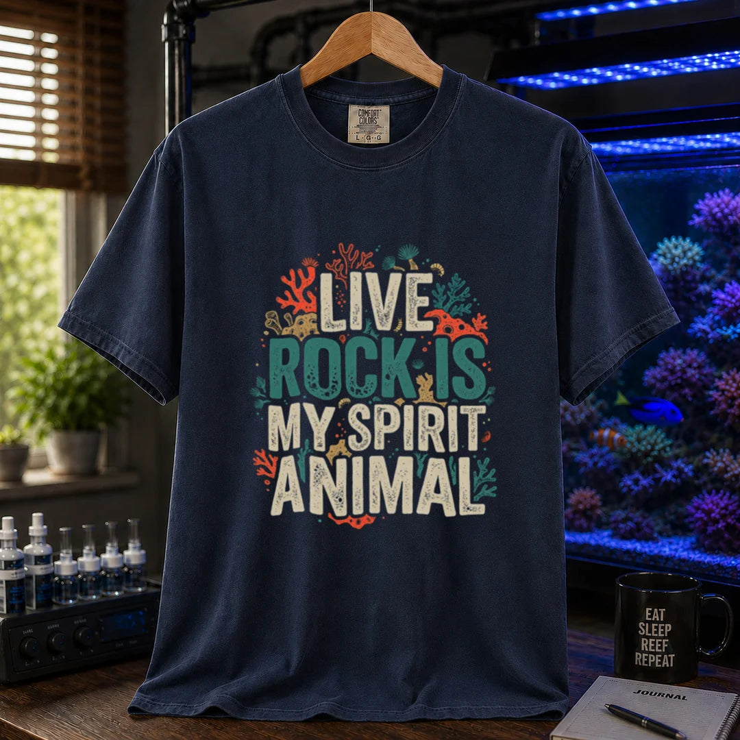 Saltwater aquarium graphic t-shirt featuring distressed cream and turquoise typography reading Live Rock Is My Spirit Animal framed by colorful coral illustrations printed on a navy tee displayed in a reef room setting