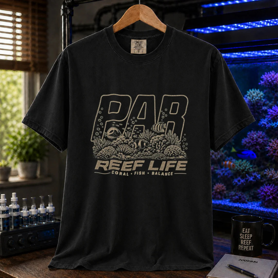 Saltwater aquarium graphic t-shirt featuring distressed cream typography reading PAR and Reef Life with an intricate engraved reef, coral, and fish illustration printed on a black tee displayed in a reef room setting