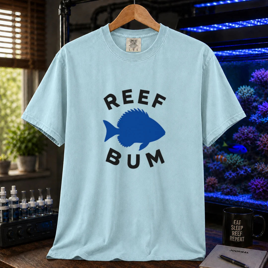 Saltwater aquarium graphic t-shirt featuring bold black typography reading Reef Bum arched around a solid blue silhouette of a fish on a light blue background