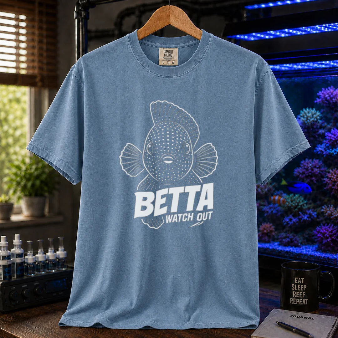 Saltwater aquarium graphic t-shirt featuring a front-facing spotted fish illustration and white typography reading Betta Watch Out on a blue shirt
