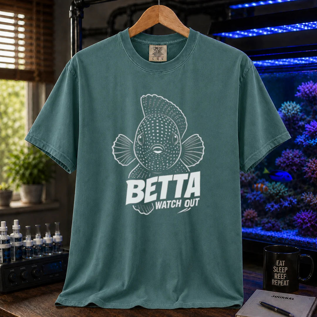 Saltwater aquarium graphic t-shirt featuring a front-facing spotted fish illustration and white typography reading Betta Watch Out on a green shirt