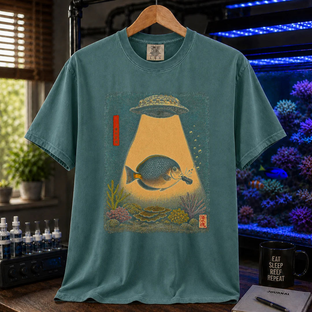 Saltwater aquarium graphic t-shirt featuring a vintage woodblock print style UFO abducting a reef fish with a tractor beam over coral on a green shirt