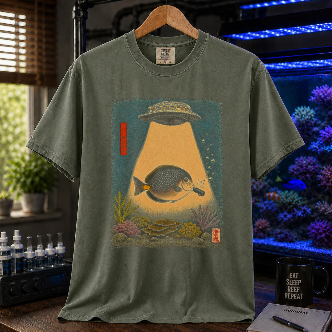 Saltwater aquarium graphic t-shirt featuring a vintage woodblock print style UFO abducting a reef fish with a tractor beam over coral on a miltary green shirt