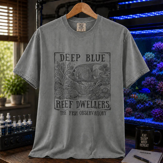 Saltwater aquarium graphic t-shirt featuring a vintage etched illustration of a fish and coral reef inside a framed box with text reading Deep Blue Reef Dwellers The Fish Observatory on a grey shirt