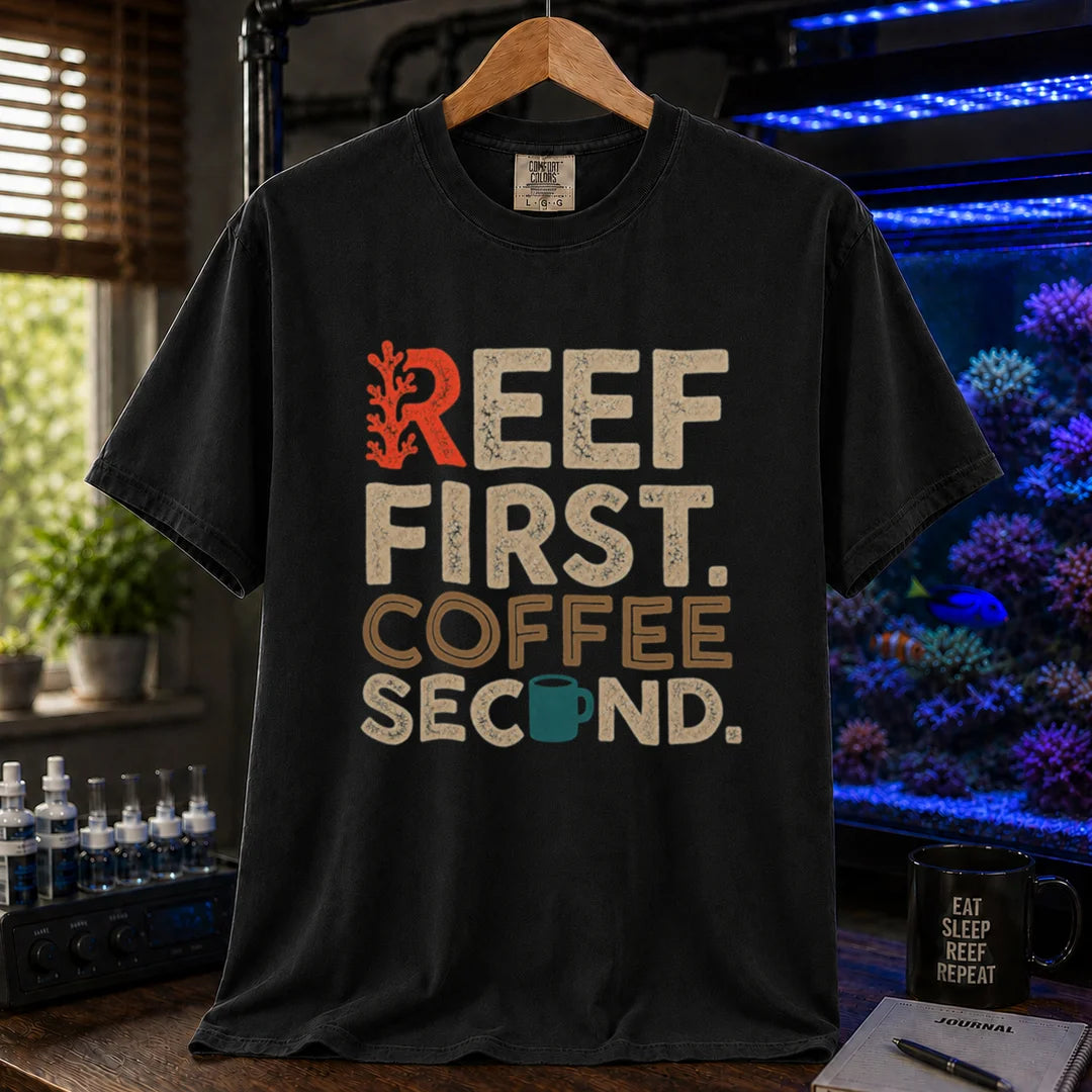 Saltwater aquarium graphic t-shirt featuring distressed typography reading Reef First Coffee Second with a red coral graphic and teal coffee mug icon on a black shirt