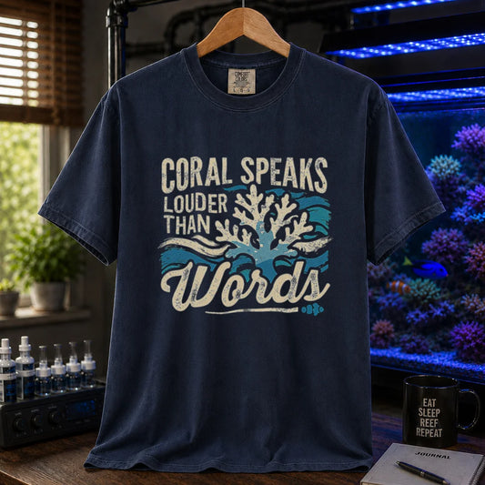 Saltwater aquarium graphic t-shirt featuring distressed typography reading Coral Speaks Louder Than Words over a blue wave and white coral design on a navy shirt