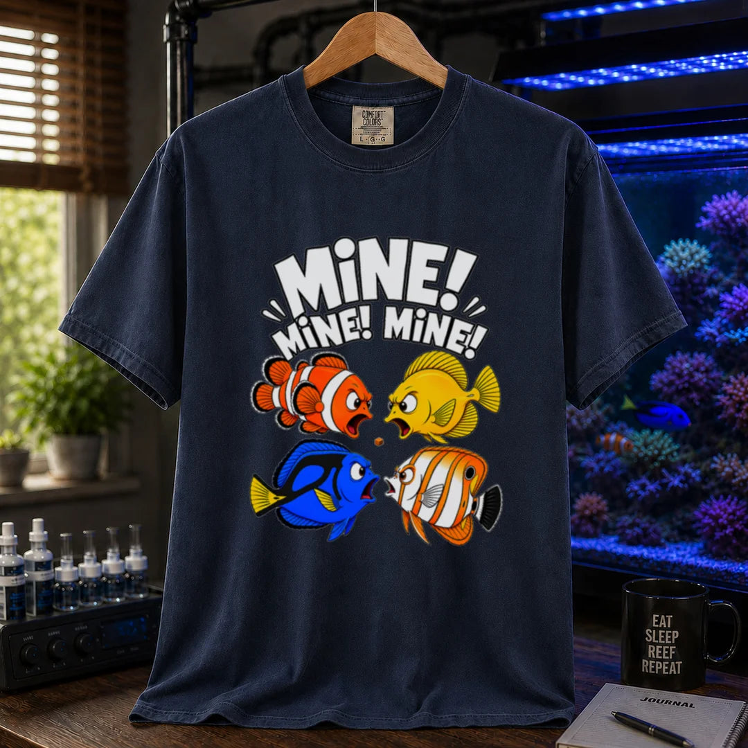 Saltwater aquarium graphic t-shirt featuring text reading Mine Mine Mine above four colorful reef fish fighting over a single piece of food on a navy shirt