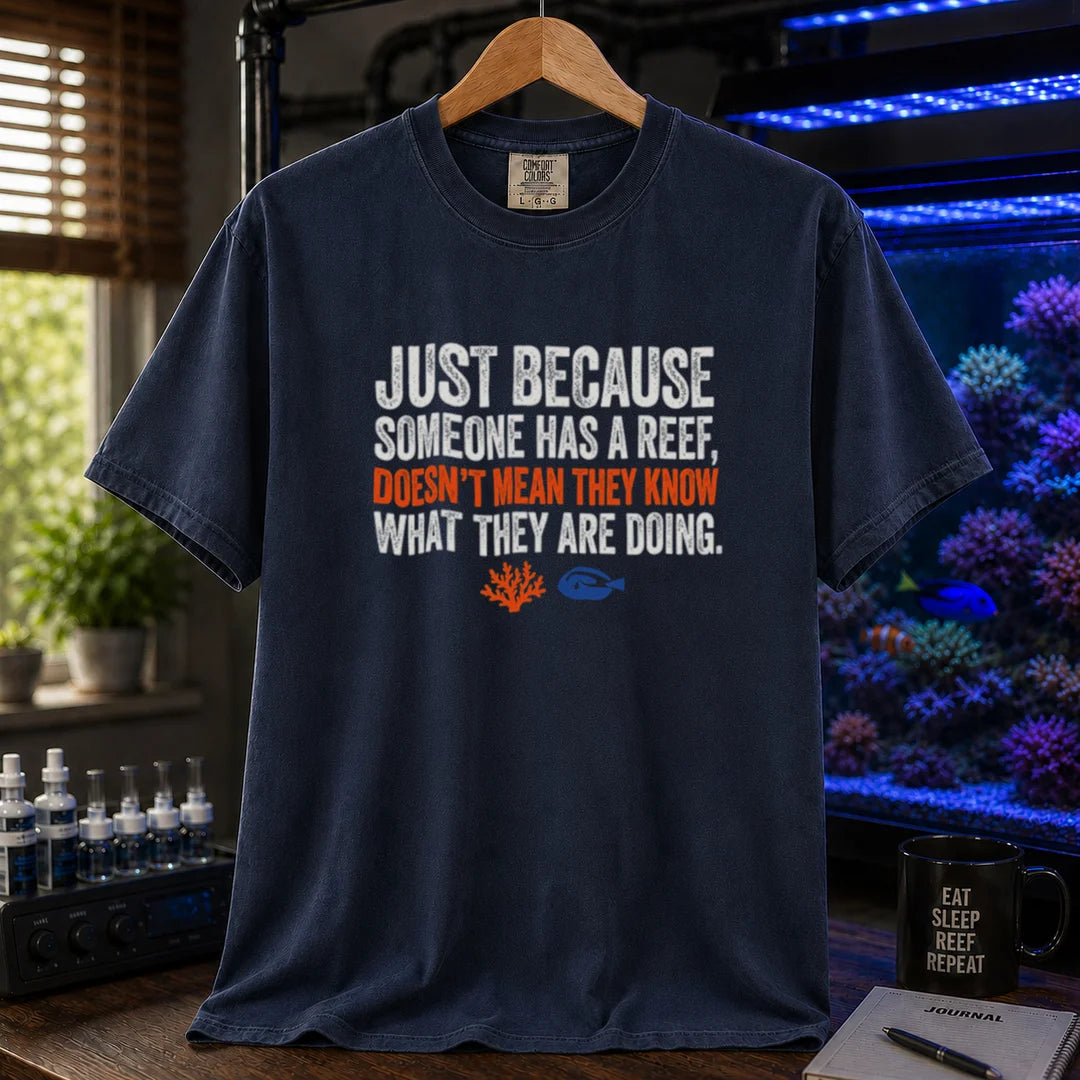 Saltwater aquarium graphic t-shirt featuring distressed white and orange typography reading Just Because Someone Has A Reef, Doesn't Mean They Know What They Are Doing on a navy shirt