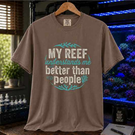 Saltwater aquarium graphic t-shirt featuring distressed circular typography reading My Reef Understands Me Better Than People with clownfish and coral graphics on a brown shirt