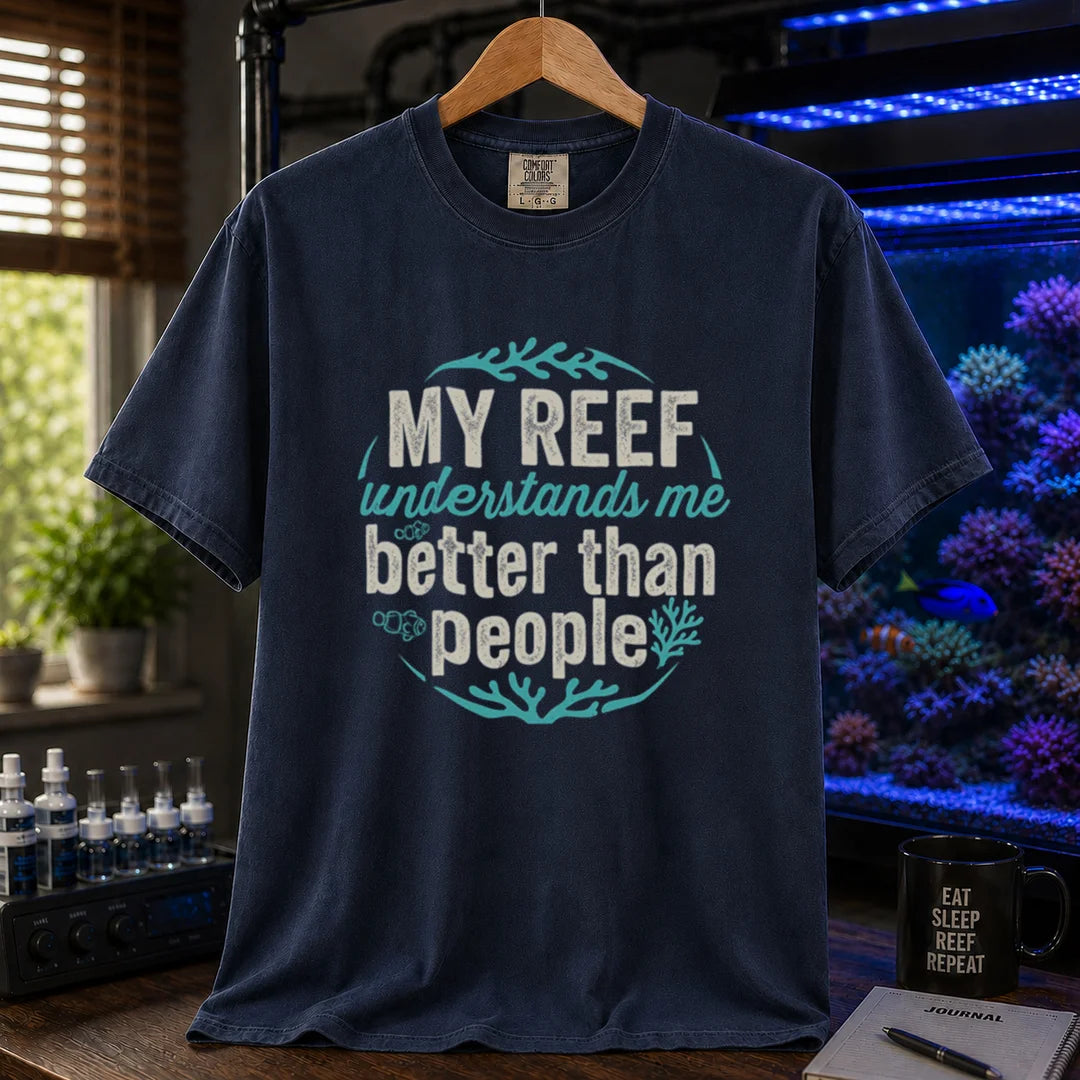 Saltwater aquarium graphic t-shirt featuring distressed circular typography reading My Reef Understands Me Better Than People with clownfish and coral graphics on a navy shirt