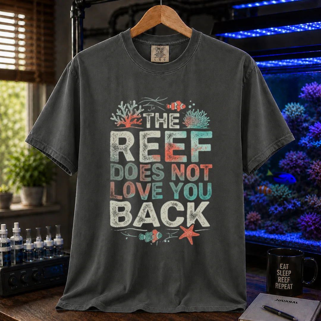 Saltwater aquarium graphic t-shirt featuring distressed multi-row typography reading The Reef Does Not Love You Back with coral and clownfish illustrations on a dark grey shirt