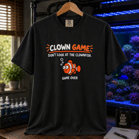 Saltwater aquarium graphic t-shirt featuring cartoon typography reading Clown Game Don't Look At The Clownfish with a goofy clownfish illustration on a black shirt