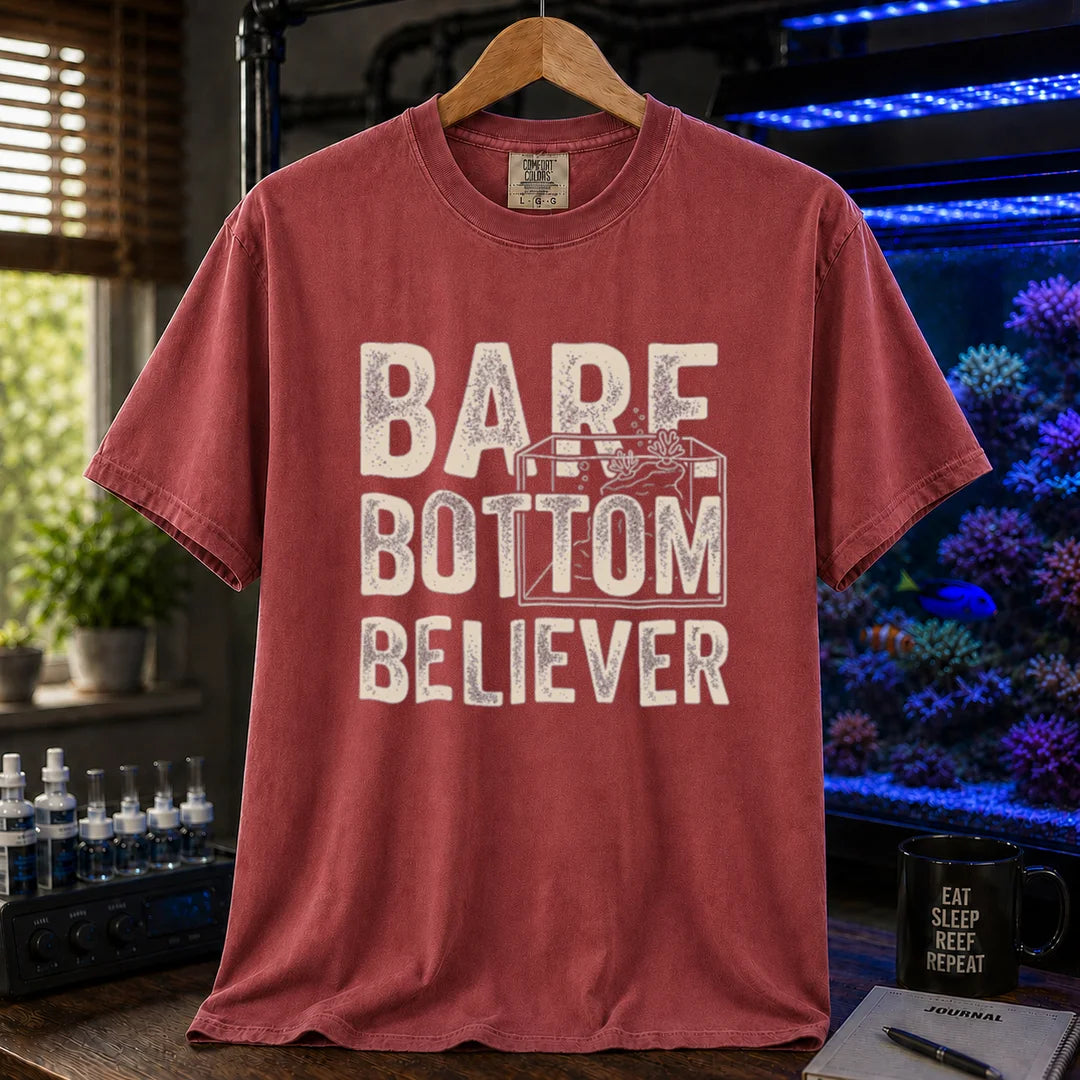 Saltwater aquarium graphic t-shirt featuring distressed typography reading Bare Bottom Believer with an aquarium outline illustration on a maroon, red shirt