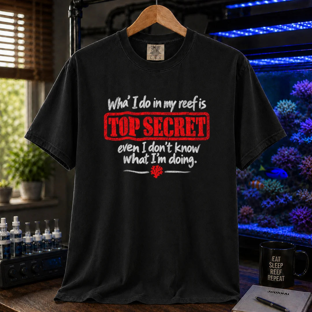 Saltwater aquarium graphic t-shirt featuring distressed typography reading What I do in my reef is Top Secret even I don't know what I'm doing with a red stamp effect on a black shirt