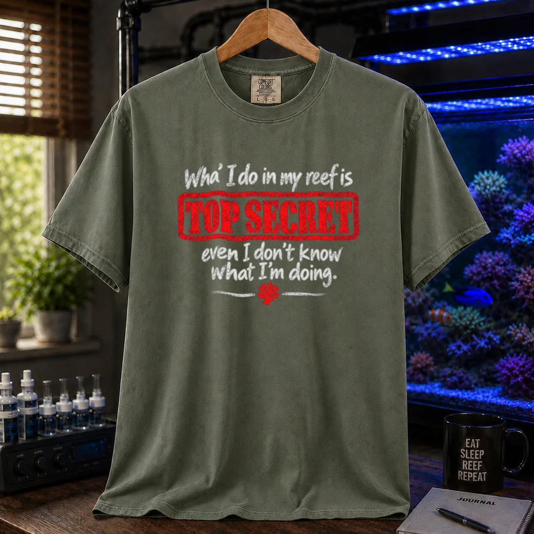 Saltwater aquarium graphic t-shirt featuring distressed typography reading What I do in my reef is Top Secret even I don't know what I'm doing with a red stamp effect on a military green shirt