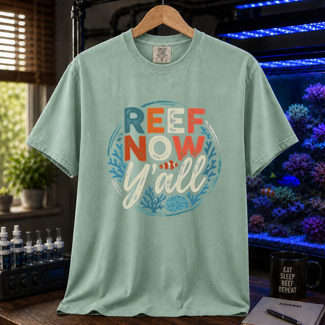 Saltwater aquarium graphic t-shirt featuring a circular distressed emblem with typography reading Reef Now Y'all and a clownfish illustration on a light green shirt