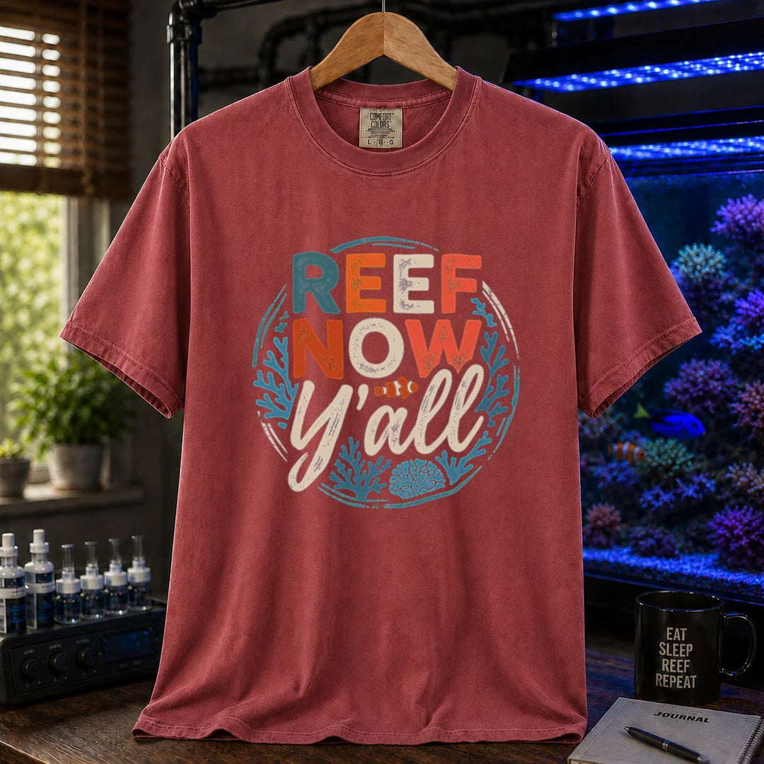 Saltwater aquarium graphic t-shirt featuring a circular distressed emblem with typography reading Reef Now Y'all and a clownfish illustration on a maroon, red shirt