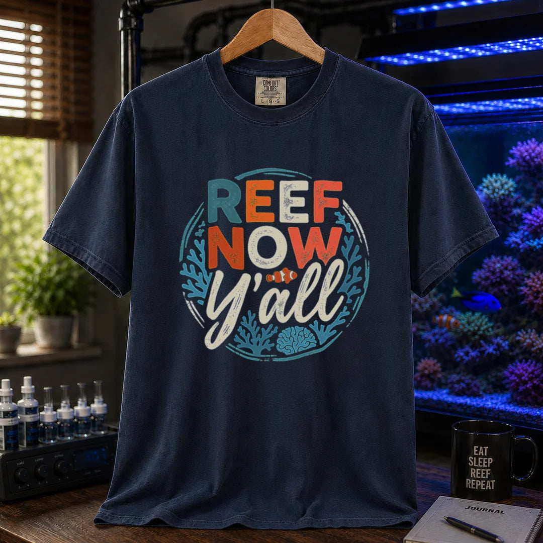 Saltwater aquarium graphic t-shirt featuring a circular distressed emblem with typography reading Reef Now Y'all and a clownfish illustration on a navy shirt