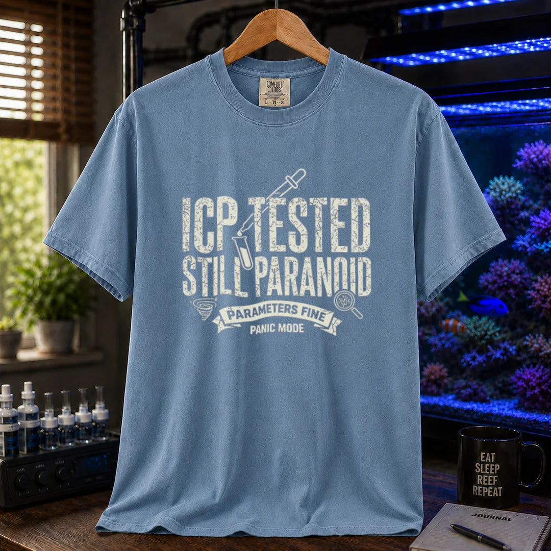 Saltwater aquarium graphic t-shirt featuring distressed typography reading ICP Tested Still Paranoid with a test tube icon and banner text reading Parameters Fine Panic Mode on a blue shirt