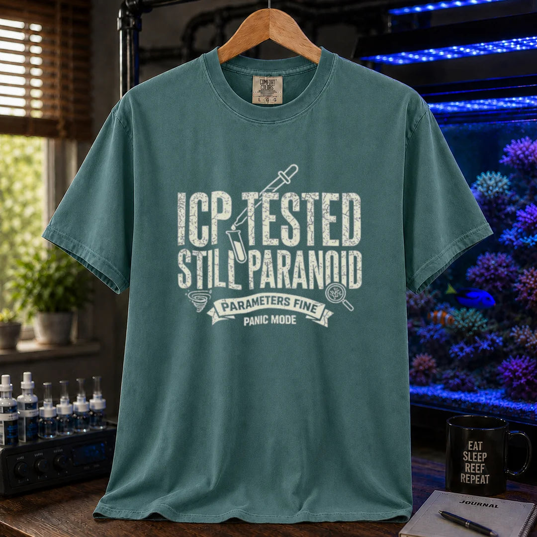 Saltwater aquarium graphic t-shirt featuring distressed typography reading ICP Tested Still Paranoid with a test tube icon and banner text reading Parameters Fine Panic Mode on a green shirt