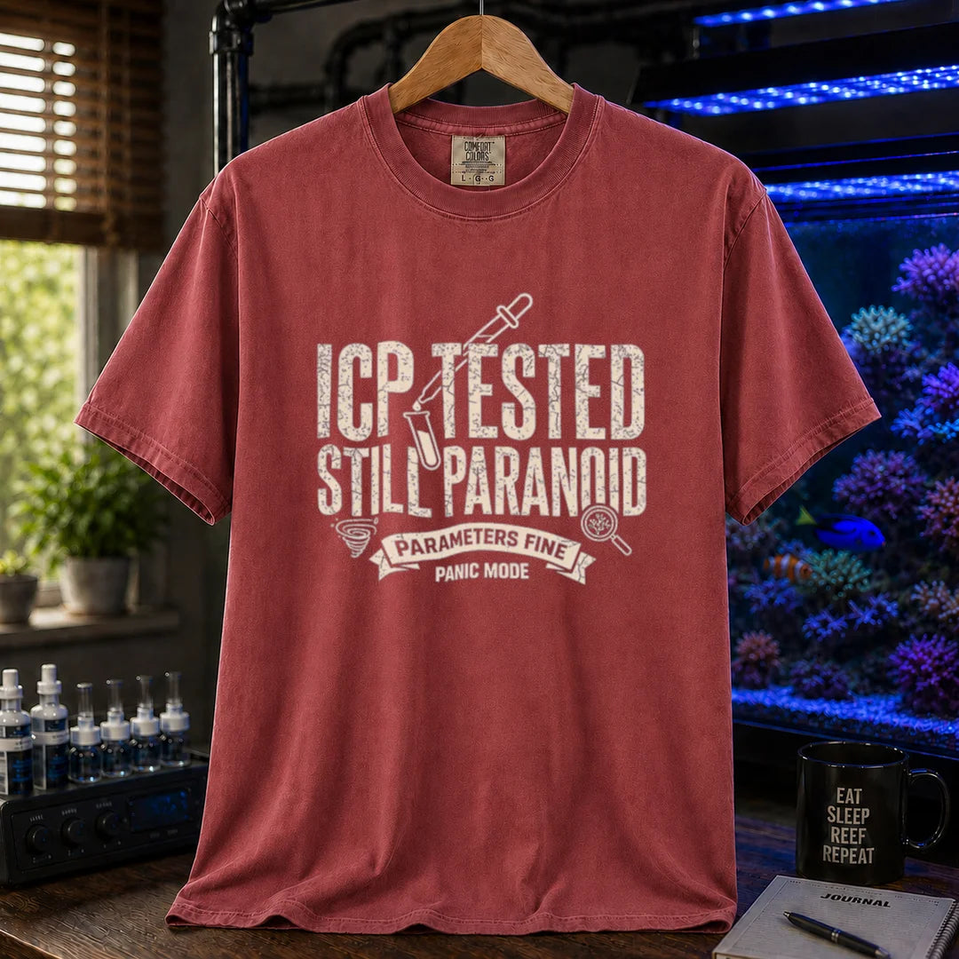 Saltwater aquarium graphic t-shirt featuring distressed typography reading ICP Tested Still Paranoid with a test tube icon and banner text reading Parameters Fine Panic Mode on a maroon, red shirt