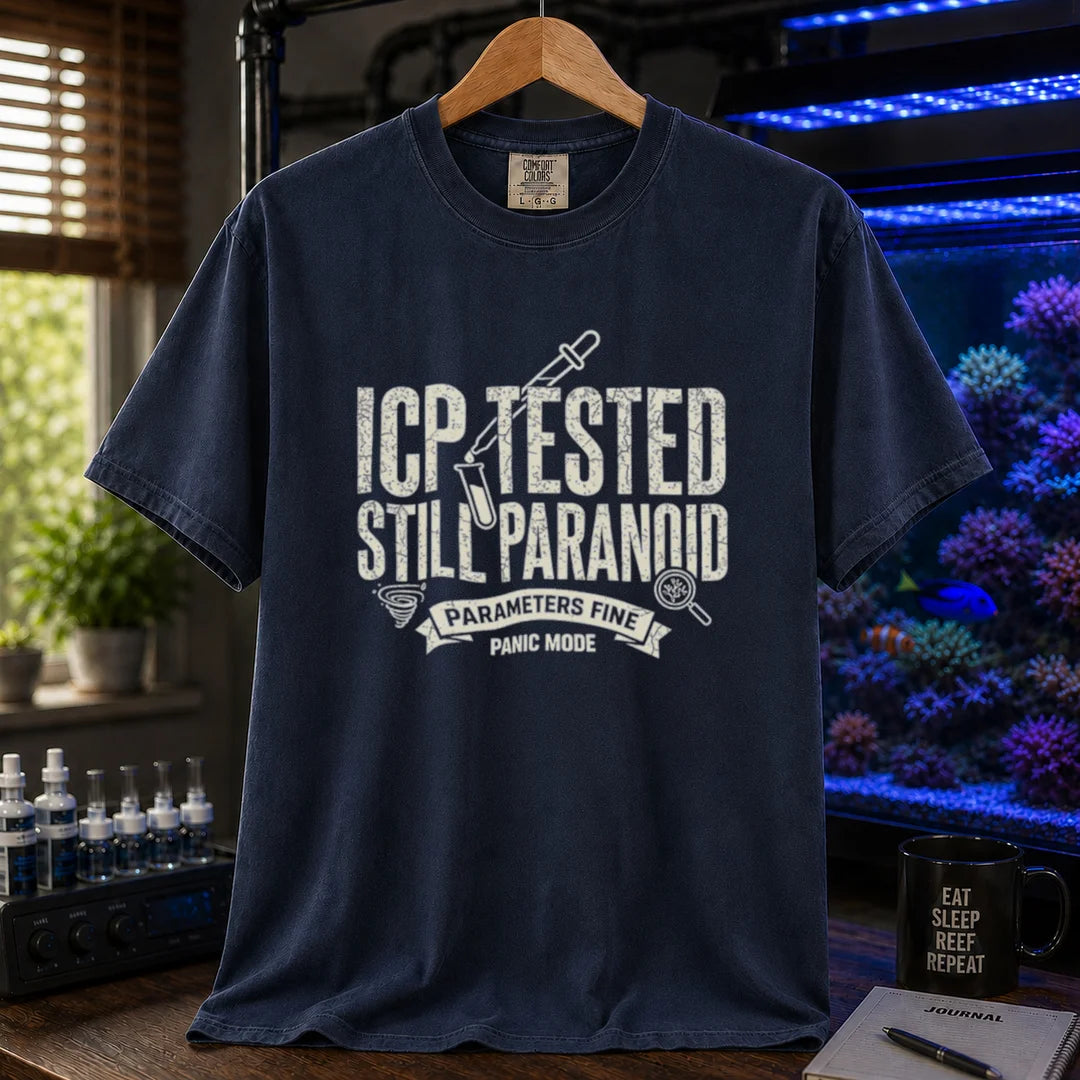 Saltwater aquarium graphic t-shirt featuring distressed typography reading ICP Tested Still Paranoid with a test tube icon and banner text reading Parameters Fine Panic Mode on a navy shirt