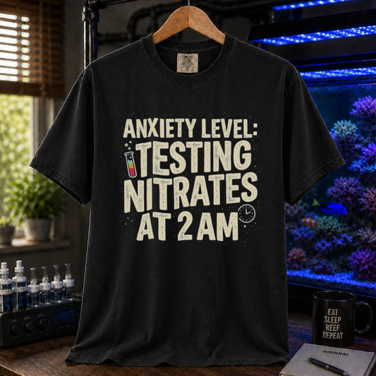 Saltwater aquarium graphic t-shirt featuring distressed typography reading Anxiety Level Testing Nitrates At 2 AM with a test tube and clock icon on a black shirt