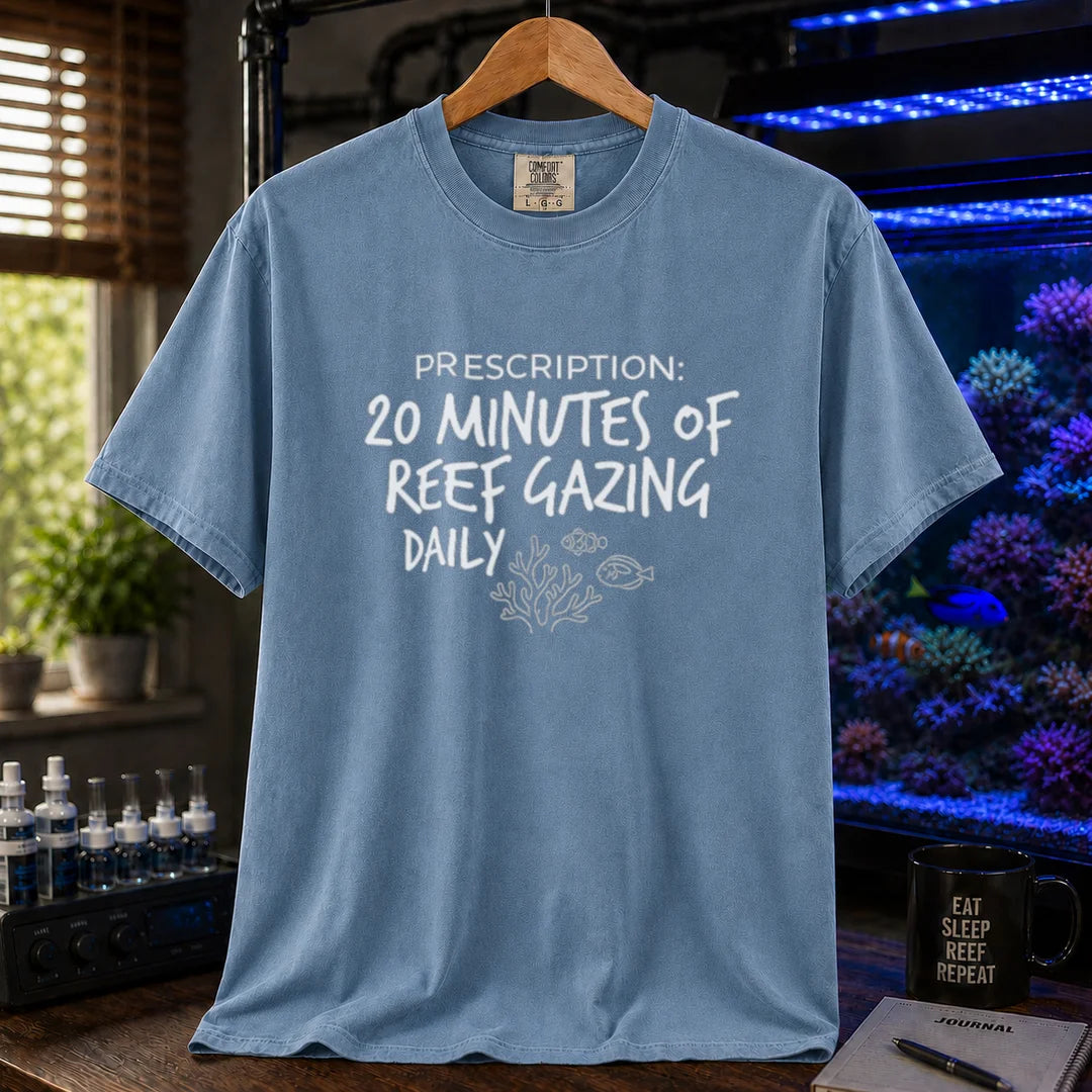 Saltwater aquarium graphic t-shirt featuring distressed handwritten typography reading Prescription: 20 Minutes Of Reef Gazing Daily with a coral and fish illustration on a blue shirt