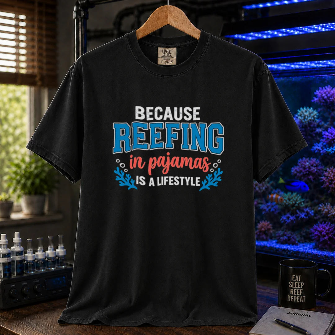 Saltwater aquarium graphic t-shirt featuring distressed typography reading Because Reefing In Pajamas Is A Lifestyle with blue coral and bubble illustrations on a black shirt
