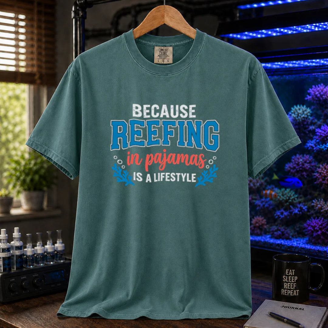 Saltwater aquarium graphic t-shirt featuring distressed typography reading Because Reefing In Pajamas Is A Lifestyle with blue coral and bubble illustrations on a green shirt