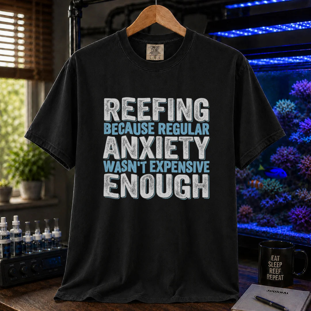 Saltwater aquarium graphic t-shirt featuring distressed block typography in white and light blue reading Reefing Because Regular Anxiety Wasn't Expensive Enough on a black shirt