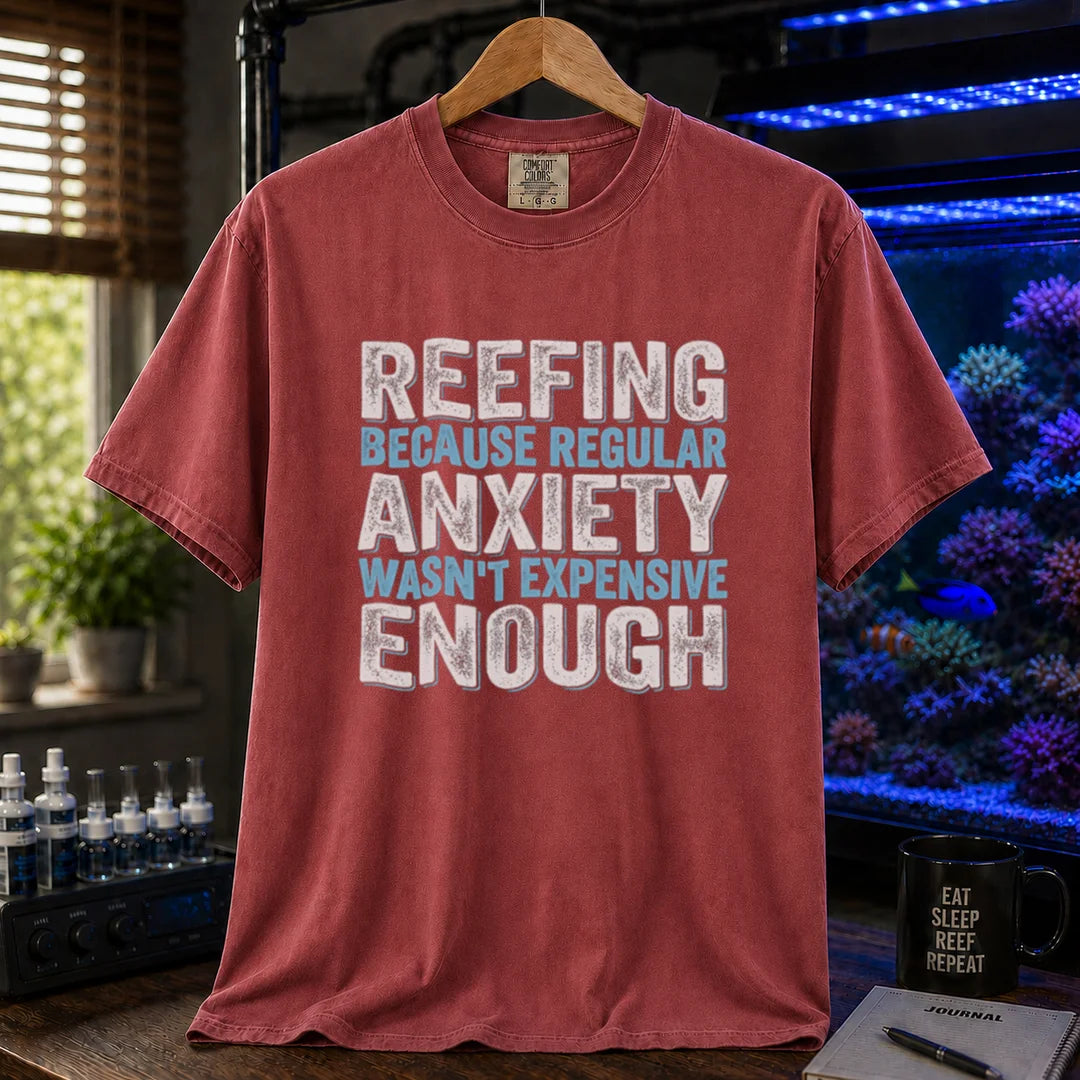 Saltwater aquarium graphic t-shirt featuring distressed block typography in white and light blue reading Reefing Because Regular Anxiety Wasn't Expensive Enough on a maroon shirt