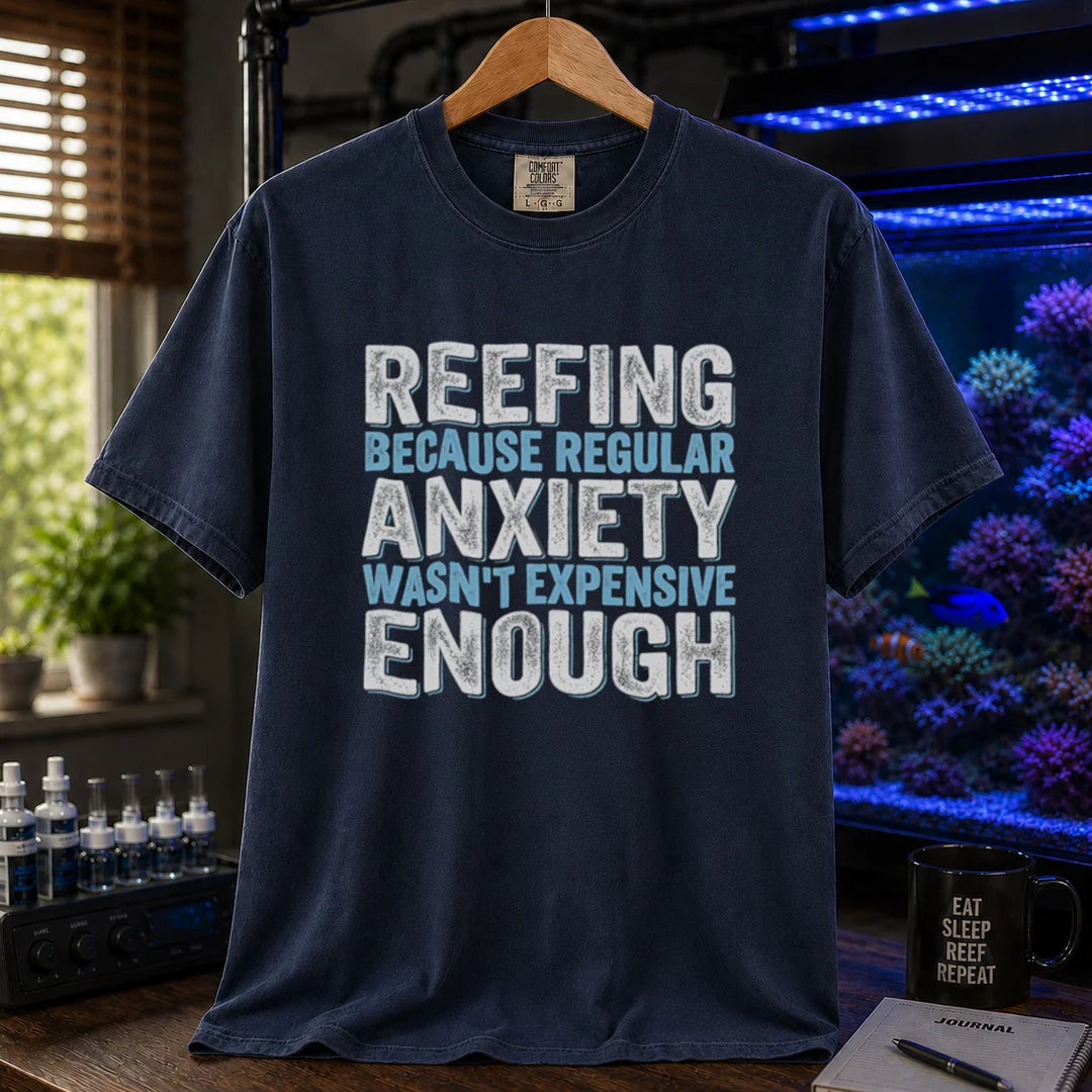 Saltwater aquarium graphic t-shirt featuring distressed block typography in white and light blue reading Reefing Because Regular Anxiety Wasn't Expensive Enough on a navy shirt