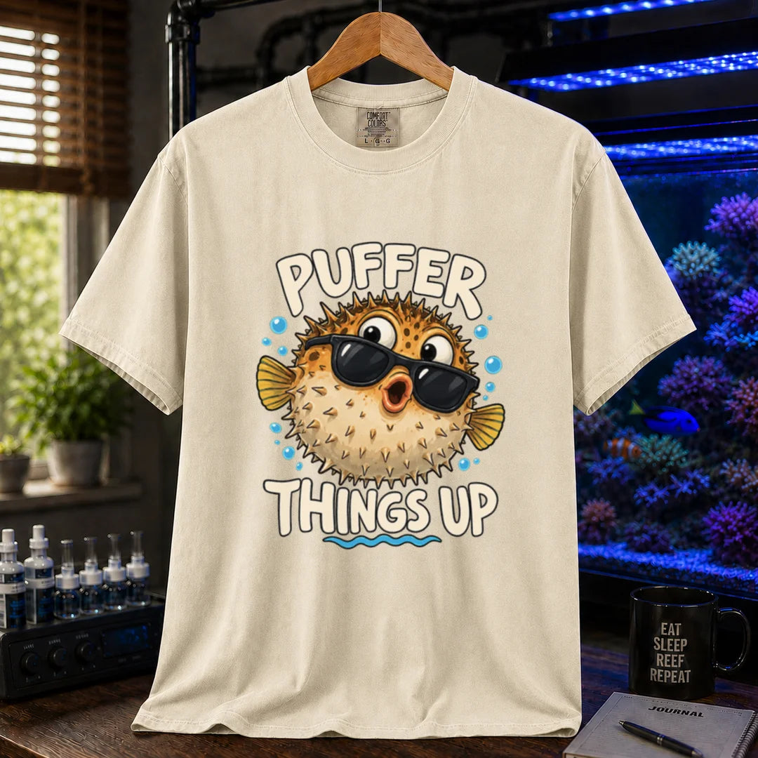 White saltwater aquarium graphic t-shirt featuring typography reading Puffer Things Up framing an illustration of a pufferfish wearing sunglasses on a beige, cream, ivory shirt