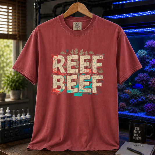 Saltwater aquarium graphic t-shirt featuring distressed block typography reading Reef Beef with red, cream, and teal accents on a maroon, red shirt