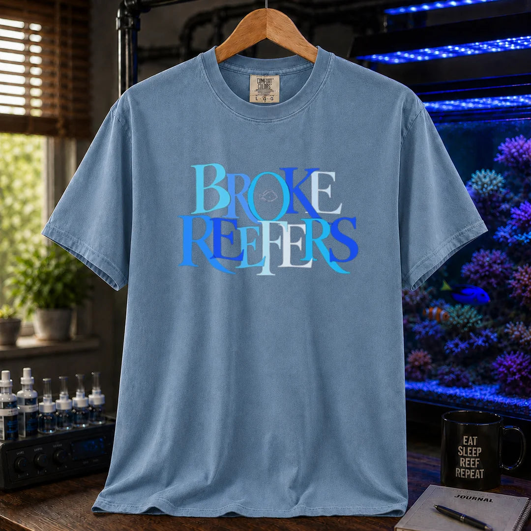 Saltwater aquarium graphic t-shirt featuring overlapping blue and white serif typography spelling Broke Reefers with a small fish outline on a blue shirt